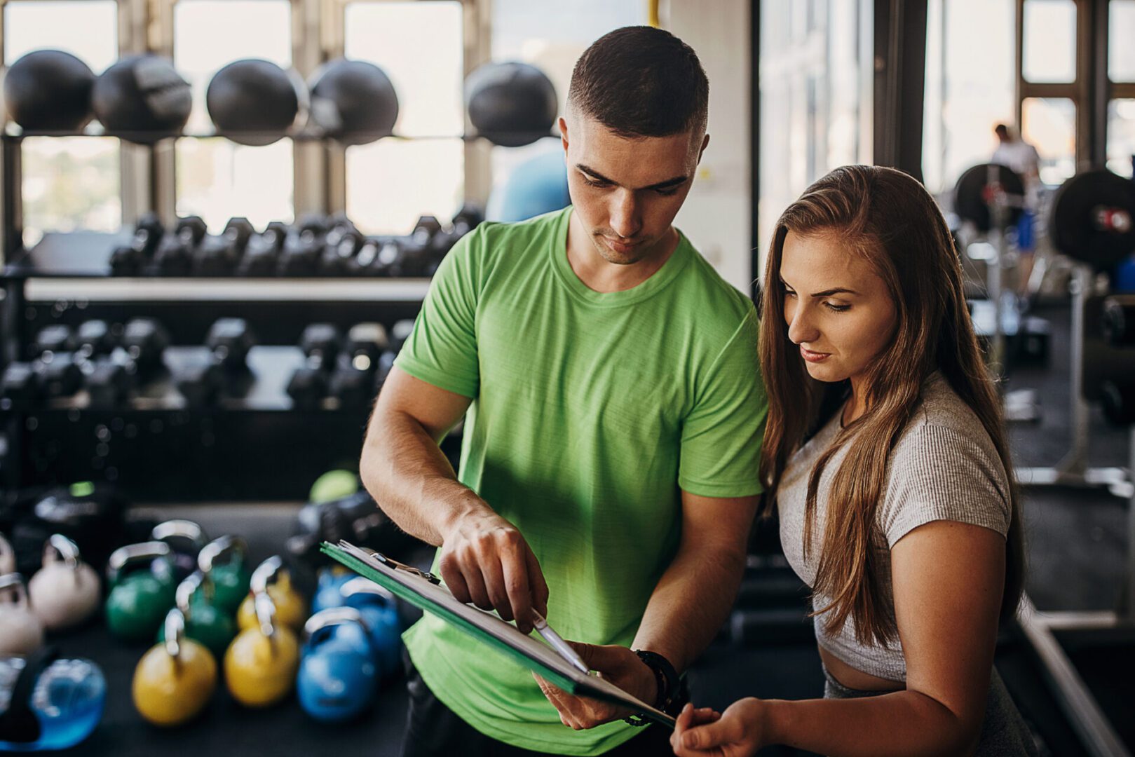 Trainer and woman reviewing workout plan together.
